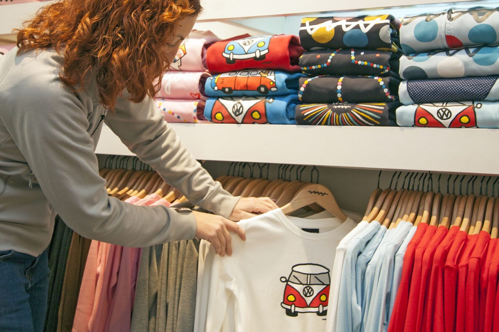 Mulher olhando blusa infantil branca 